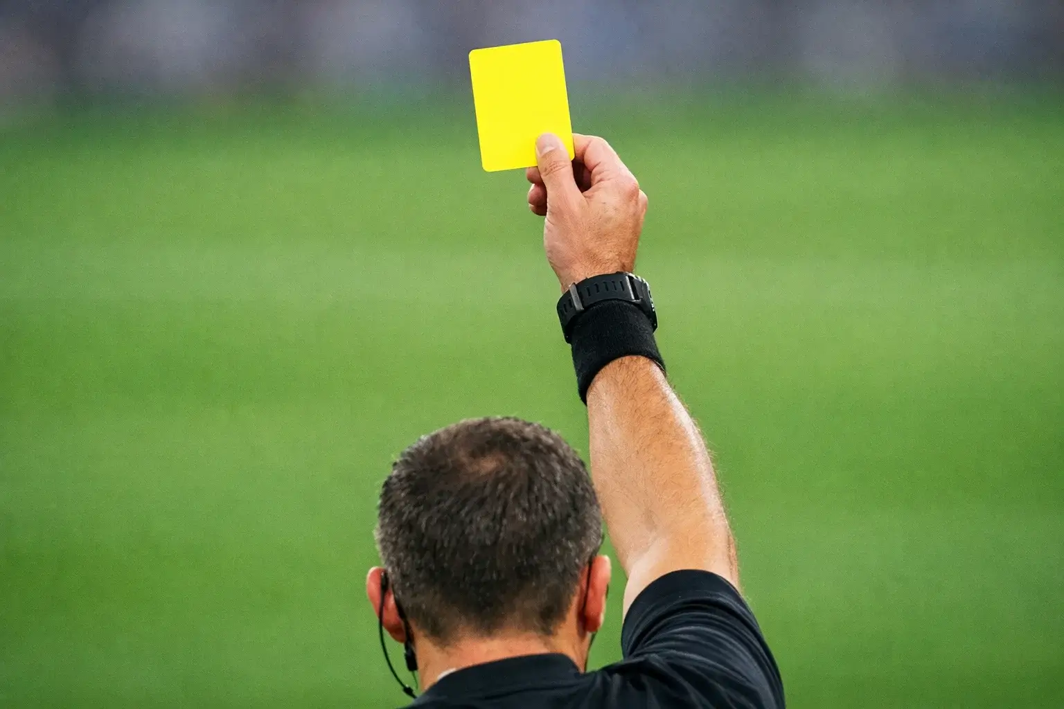 Scheidsrechter toont gele kaart tijdens voetbalwedstrijd